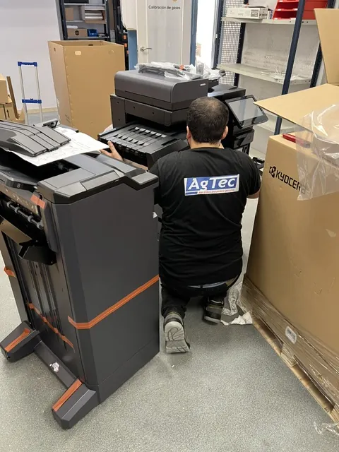 Técnico de AGTEC instalando una fotocopiadora Kyocera con finisher